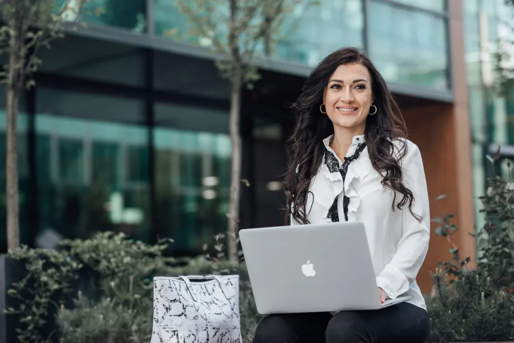 Fotografia biznesowa – portret kobiety z laptopem przed biurowcem