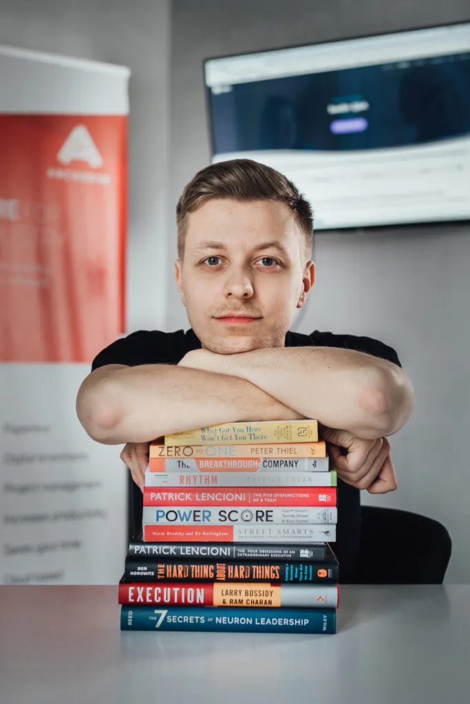 Zdjęcie biznesowe eksperta ze stosem książek